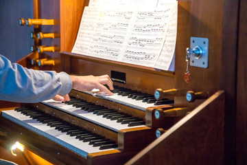 Close up view of a organist playing a pipe organ