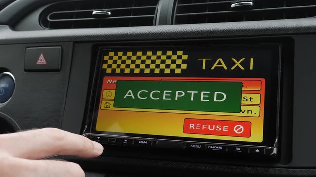 Taxi driver accepting a new client request on the touchscreen of his car.