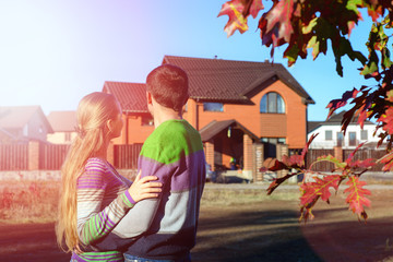 Rear view of young couple looking at their new house