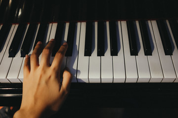 Obraz premium young woman use left hand play piano has piano key are background. this image for music, artist, art, instrument, entertainment concept