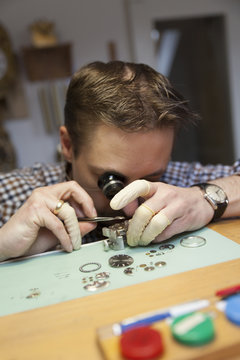 Clockmaker working in workshop