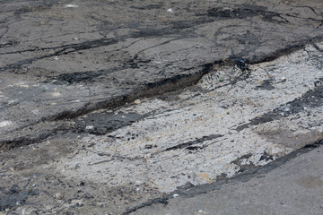 Construction of a road in the streets of yards. New asphalt on the road. Streams of hot bitumen when laying asphalt.