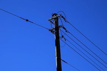 Stromkabel an einem Freileitungsmast, Strommast mit blauen Himmel
