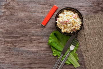Crab salad in a plate on a wooden table.Rustic style.Top view.