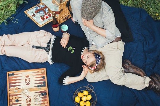 Spring Picnic - Overhead of Man and Pretty Woman on Blue Quilt and Enjoying the Outdoors