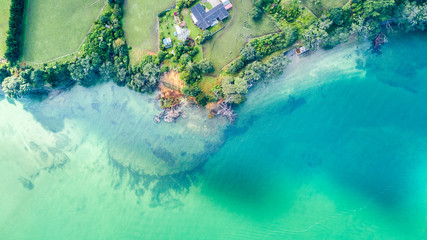 Aerial view on small suburb on a sunny ocean beach. Whangaparoa, Auckland, New Zealand. - obrazy, fototapety, plakaty
