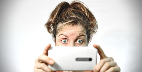 Fototapeta premium Mujer mirando un teléfono móvil sorprendida