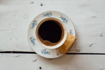 White cup of coffee on the white wooden table