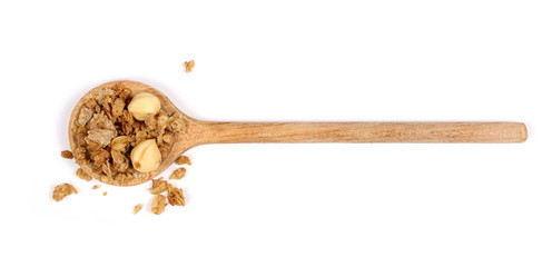 Crunchy granola, muesli pile in metal spoon with nuts isolated on white background, top view