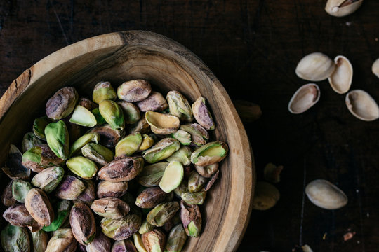 Shelled pistachio nuts in a wooden bowl