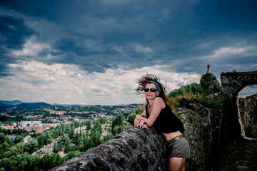 Femme en haut du rocher Saint-Michel d'Aiguilhe  au Puy-en-Velay pendant un orage
