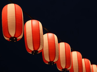 Paper red-white japanese lanterns Chochin shines on dark sky © marmoset