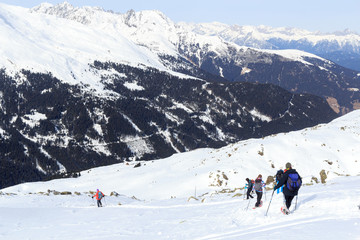 Fototapeta na wymiar Group of people hiking on snowshoes and mountain snow panorama with blue sky in Stubai Alps, Austria