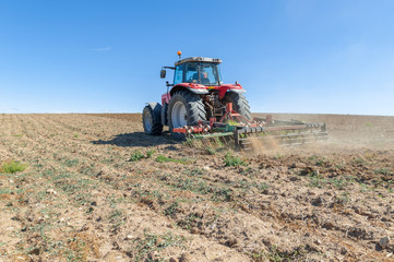 Obraz premium agricultural tractor in the foreground with blue sky background.