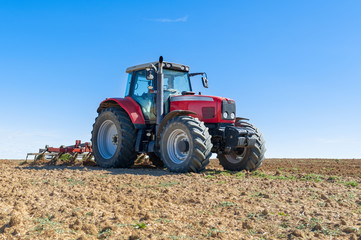 Fototapeta premium agricultural tractor in the foreground with blue sky background.