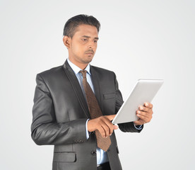 Handsome young businessman browsing on tablet pc, isolated very professionally