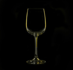 Silhouette of wineglass with yellow illumination