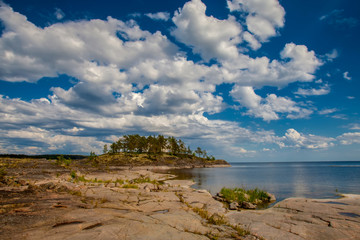 Fototapeta na wymiar Island with stony shore. Island under the clouds. Karelia. Russia. Ladoga lake.