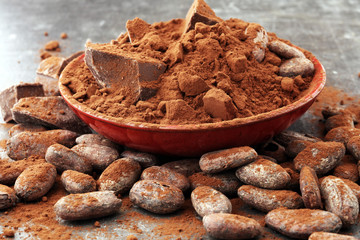 Raw cocoa beans, cocoa powder and chocolate pieces.