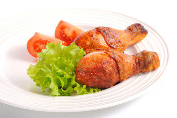 Grilled chicken leg with tomato on white background