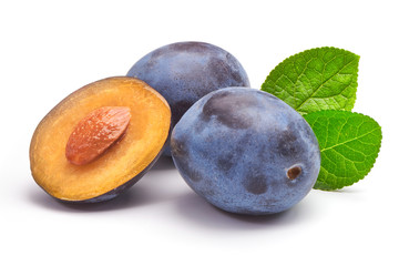 Isolated plums. One and a half of blue plum fruit with leaves isolated on white background