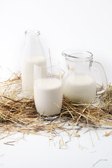 A jug of milk and glass of milk on white background.