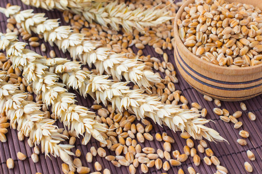 Grains, spikes of wheat  on brown background.
