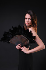 Young woman with a black feather fan and hat