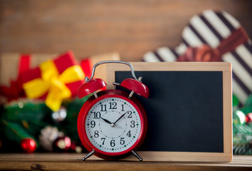 Alarm clock and blackboard on wooden table