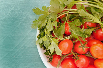 cherry tomatoes with parsley and on wooden background.
