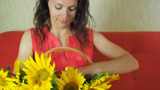 Happy woman with sunflower oil and a basket of sunflowers. Girl with a bottle of sunflower oil.