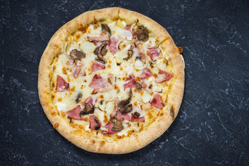 Pizza Carbonara on black stone background. Italian Pizza Carbonara with Bacon, mushrooms and Cheese close up.