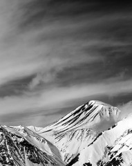 Black and white winter snowy mountains in sun windy day