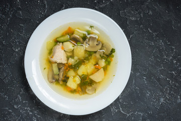 Soup with Mushrooms and chicken on stone background, top view.