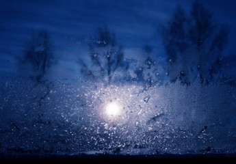 Frosty pattern at a winter window, moon night