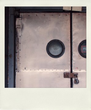 Old  snapshot print of an locked old metal door with round windows