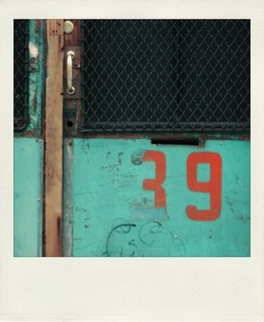 Old  snapshot print of a green wall with the number 39 on it