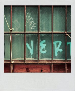 Old  snapshot print of an old window with metal bars and graffiti