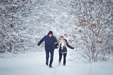 Happy Couple Having Fun Outdoors in Snow Park. Winter Vacation