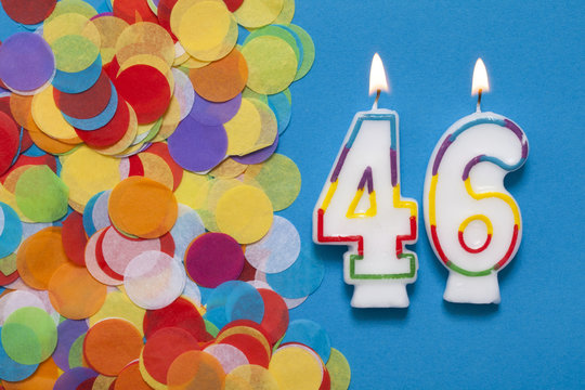 Number 46 celebration candle with party confetti