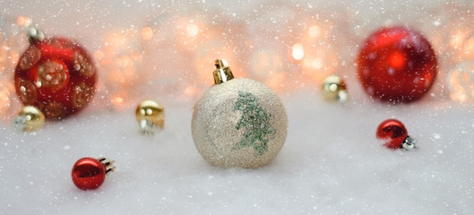 red and gold Christmas balls on the background lights and artificial snow