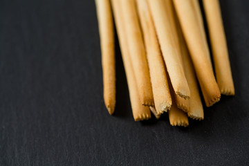 bread sticks on black stone surface