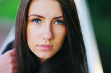 Gorgeous portrait of cute young long-haired girl with beautiful blue eyes closeup