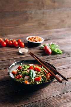 Raw zucchini spaghetti with pesto and cherry tomatoes
