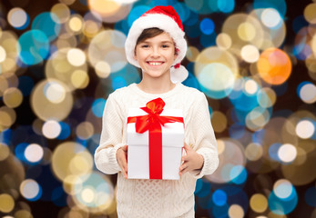 smiling happy boy in santa hat with christmas gift