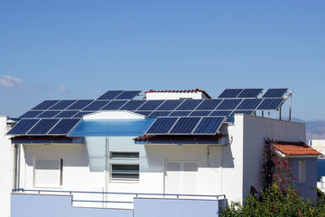 Fototapeta premium Roof with solar panels fragment under sunny blue sky. Greece.