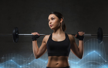 Fototapeta na wymiar young woman flexing muscles with barbell in gym