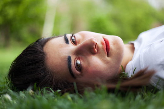 Young  beautiful woman lying on a grass