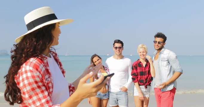 Girl Taking Photo Of People Group On Beach On Cell Smart Phone Happy Cheerful Man And Woman Posing Tourists On Vacation Slow Motion 60
