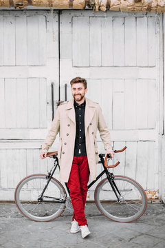 Man standing in a front of a bicycle.